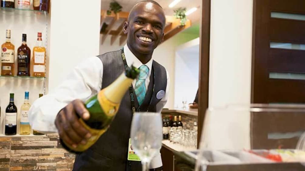airport lounge bartender pouring drinks in Nassau