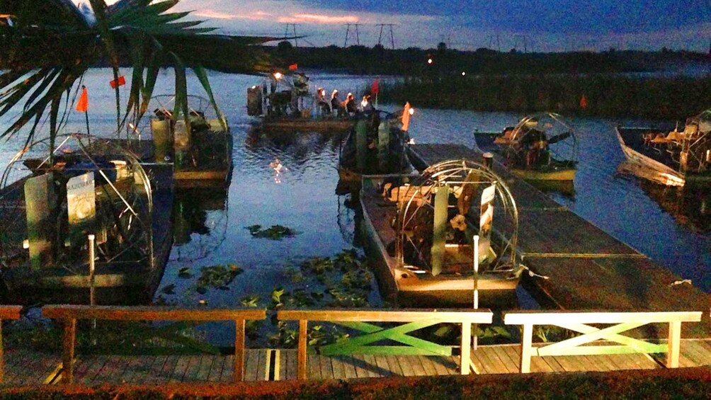 Airboats tied up at docks at dusk