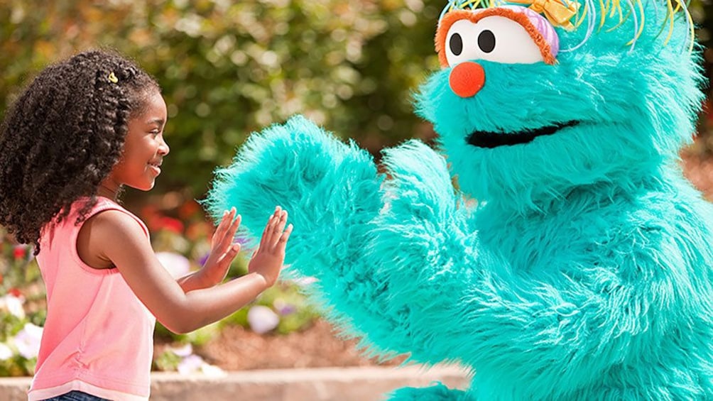 Show item 3 of 8. Girl playing with costume character in Sesame Place