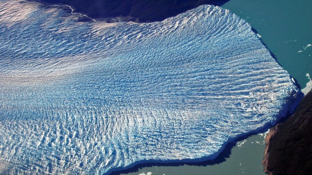 Aerial view of a glacier descending into the ocean