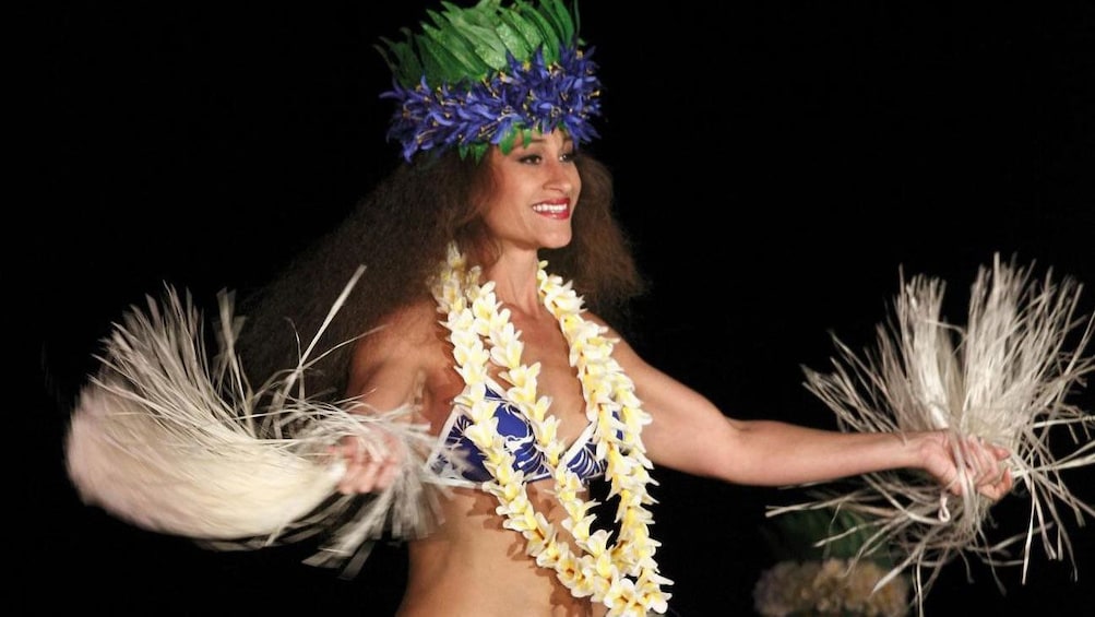 Luau performer with fans and colorful head dress