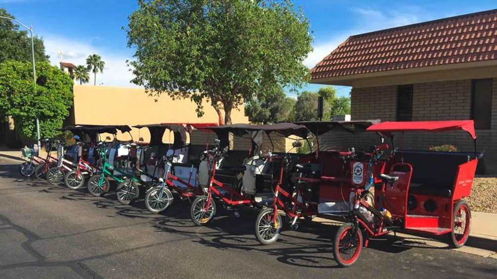 Angled view of several pedicabs parked along street.