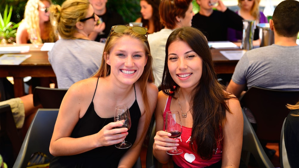 Show item 3 of 10. Pair of women with wine at a winery in Hunter Valley
