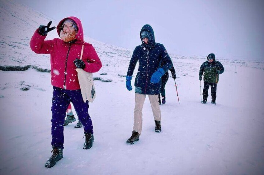 A group walking over the snow to reach Fagradalsfjall volcano in the winter.