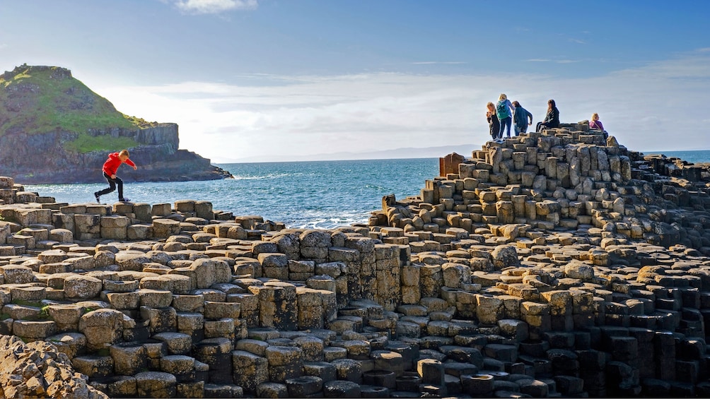 people walking on rock formations in ireland 