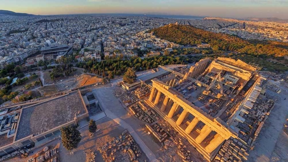 ariel shot of the sun setting against the Acropolis in Athens