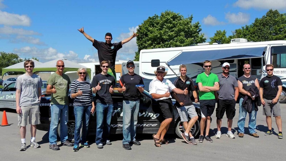 Show item 5 of 5. group of participants lined in front of stunt car in Ontario
