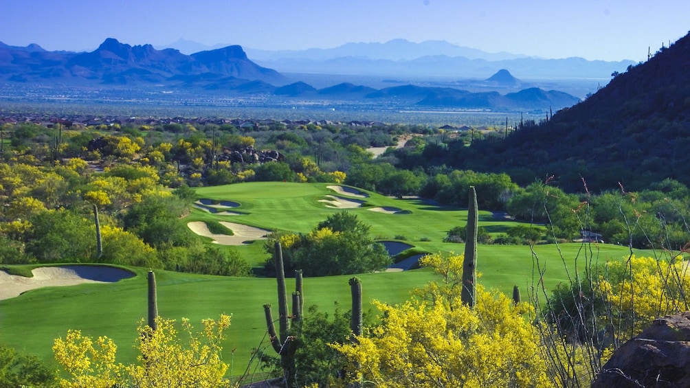 Beautiful landscape view of golf course with mountains in the distance.