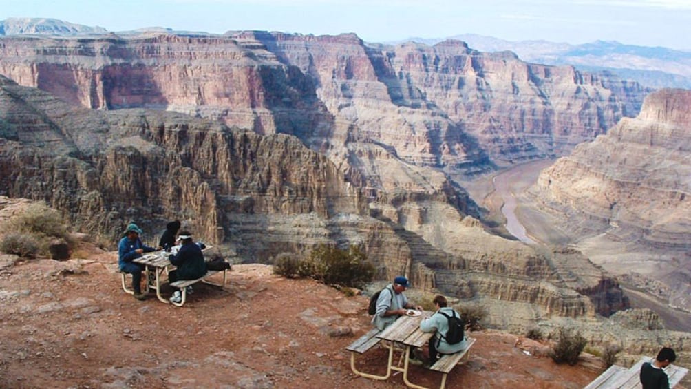 Aerial view of Grand Canyon with tourists lounging at picnic tables.