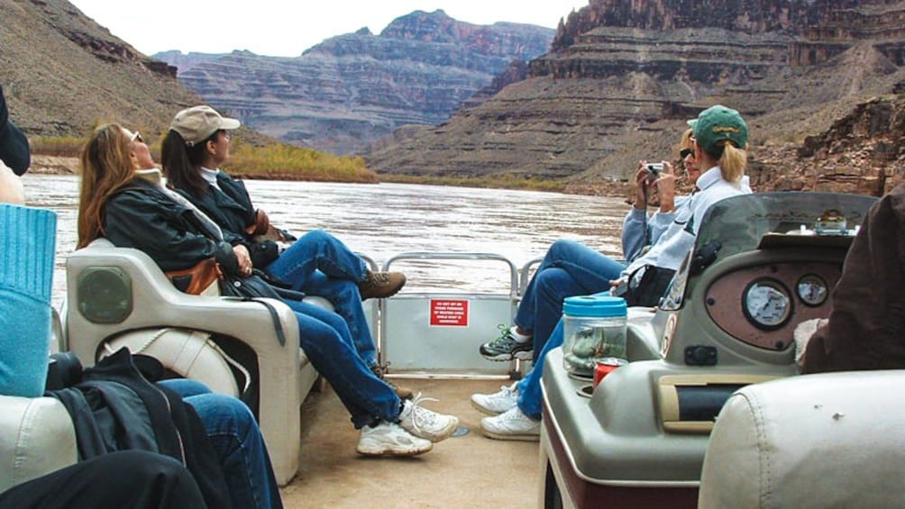 Several tourists enjoying boat ride through Grand Canyon.