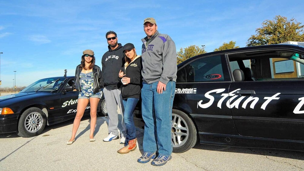 Show item 5 of 5. group standing next to parked stunt cars in Ontario