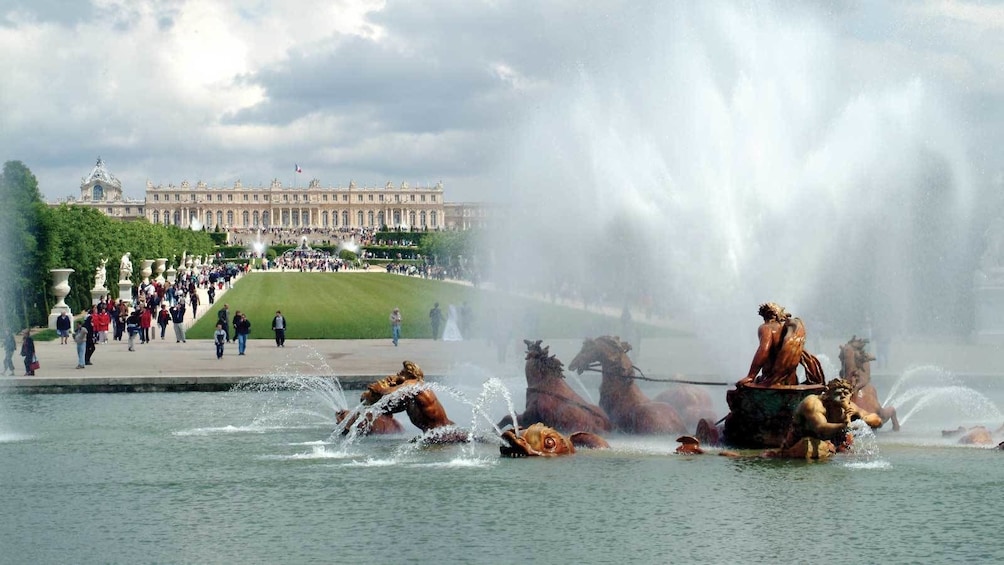 groups of visitors walking along the gardens in Versailles