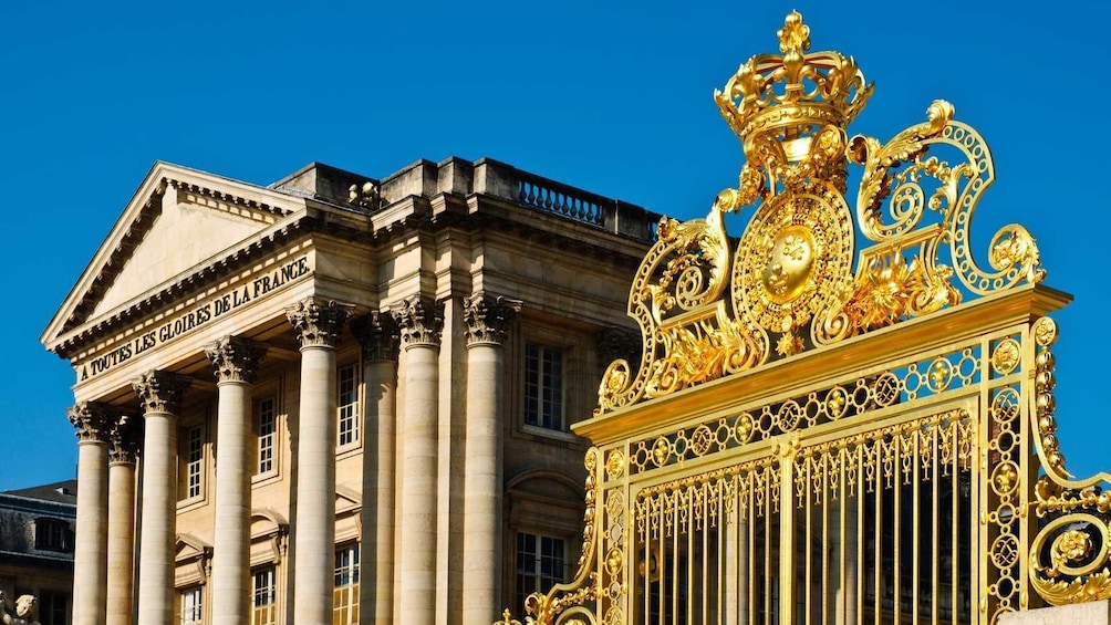 a golden gate outside of historic buildings in Paris