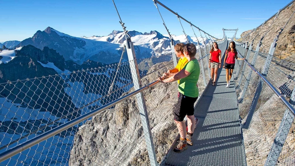 looking over the mountain ranges from a fenced walkway in Switzerland