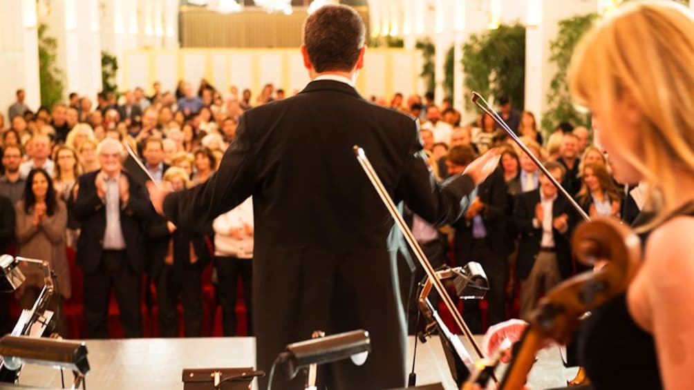 Conductor bows in front of orchestra