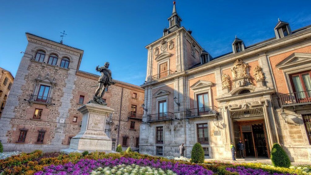 Apri foto 4 di 6. Buildings with a statue and garden in Plaza de la Villa in Madrid