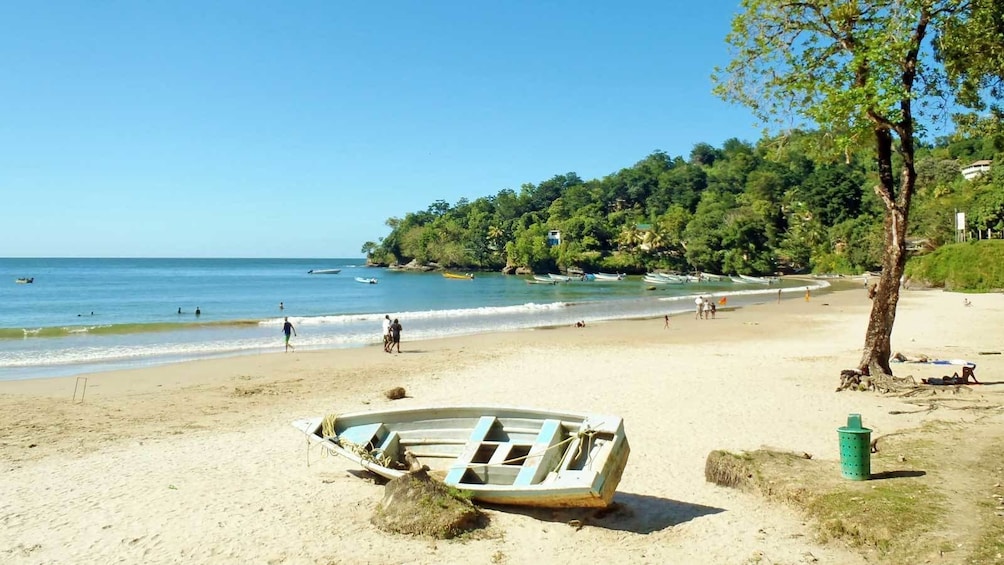 boat resting against a rock at the beach in Trinidad and Tobago