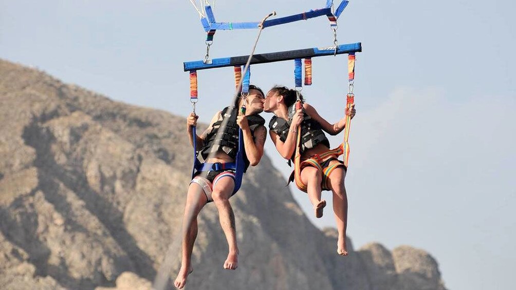 Charger l’élément 5 sur 5. Parasailing couple kissing in Santorini