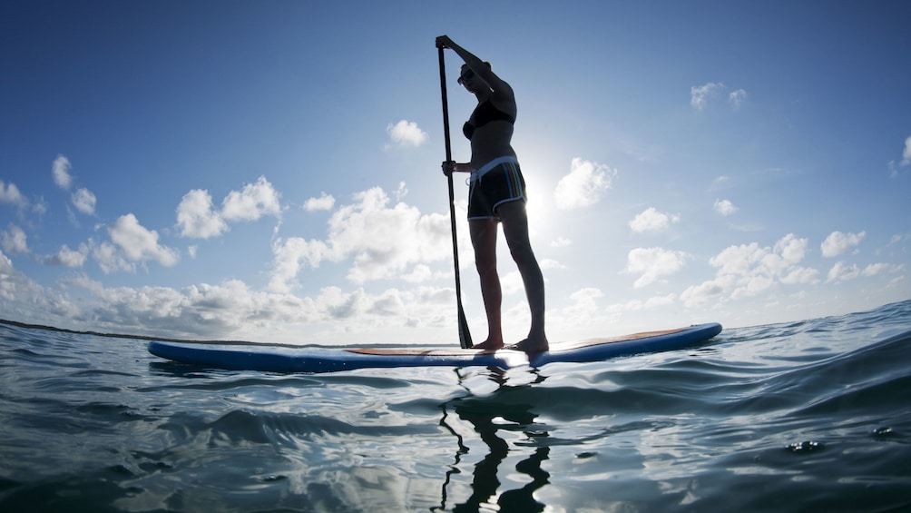 Silhouette of a woman on a standup paddleboard in Santorini