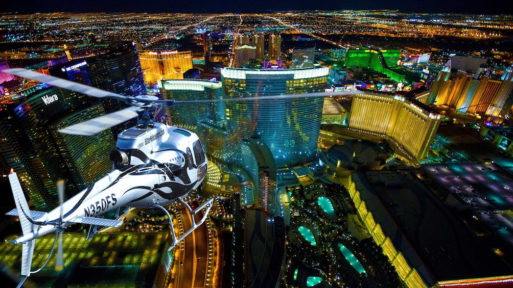 Helicopter flying over Vegas strip at night.