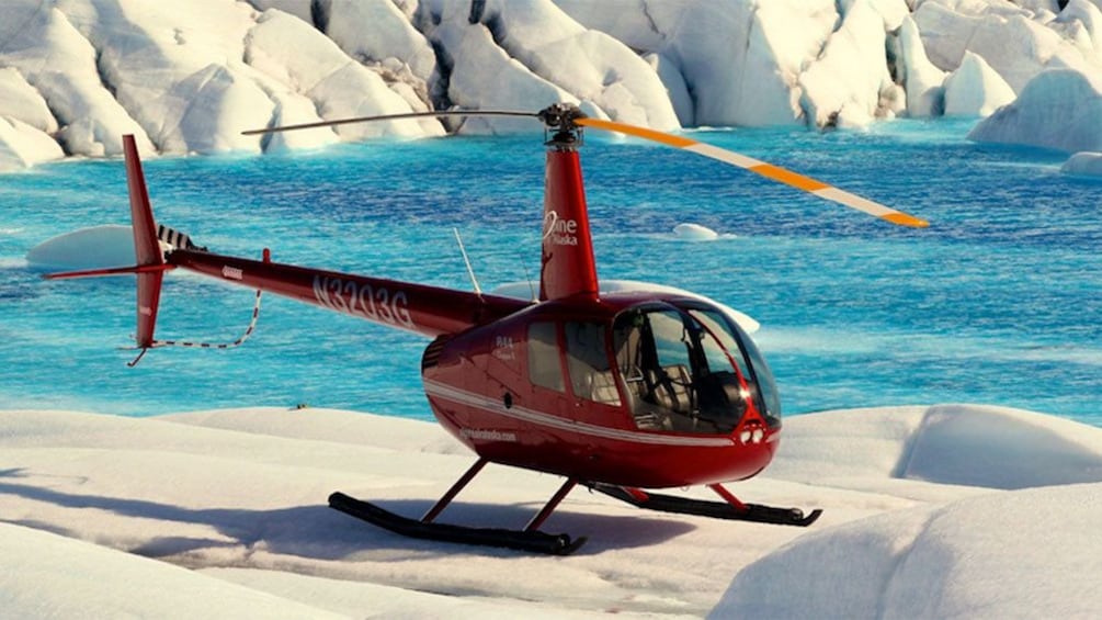 Helicopter landed on a glacier near a lake in Anchorage