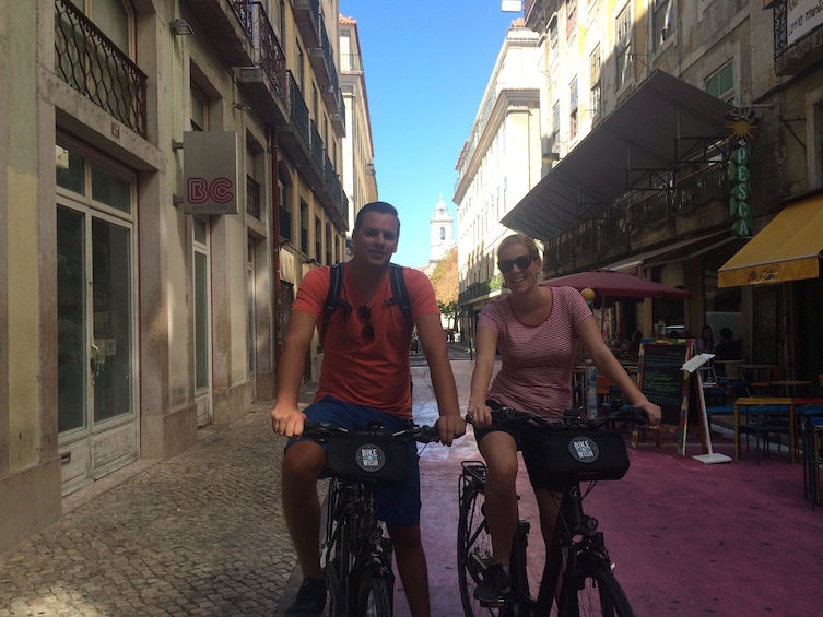 Foto 2 van 5. Couple riding bikes in Lisbon