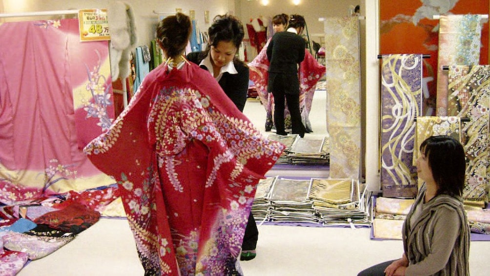 Show item 2 of 5. Woman being fitted for a kimono