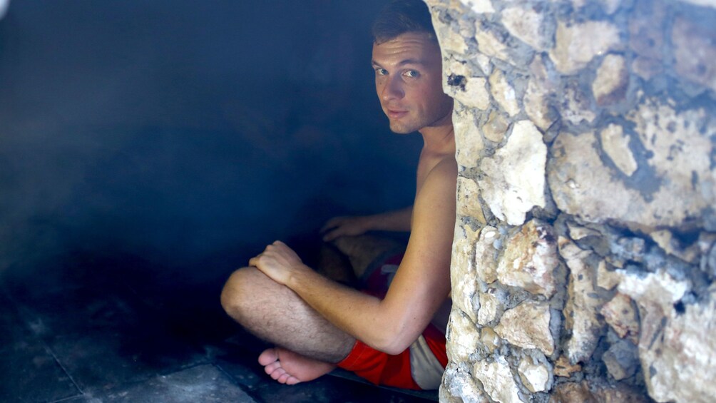 Man sitting in hut for Temazcal Ritual
