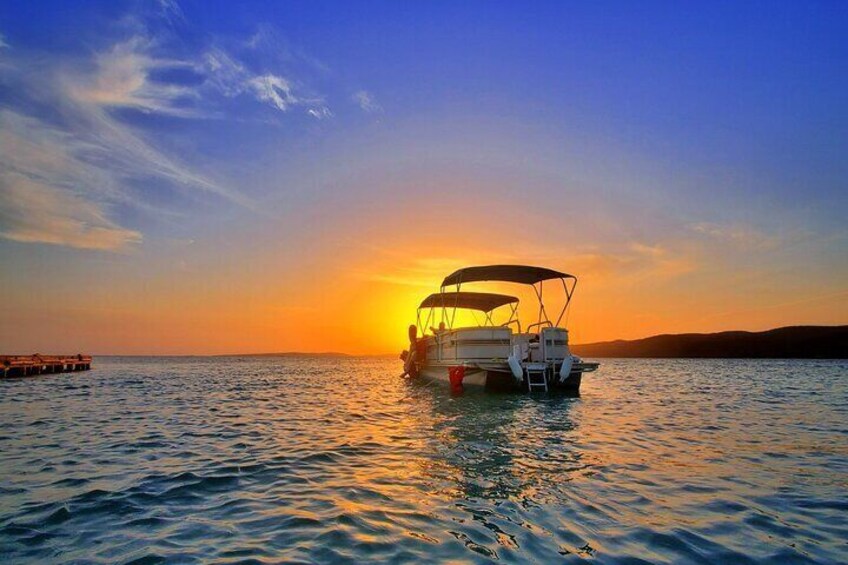 Our 12 passenger pontoon by the gorgeous Caribbean Sunset of La Parguera Biobay, part of the private Snorkeling, Sunset and Bioluminiscense Swim Experience by Bucketlist Tours.