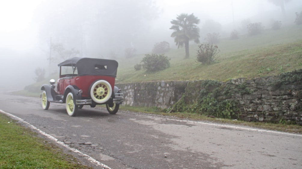 Show item 4 of 5. antique car on misty road