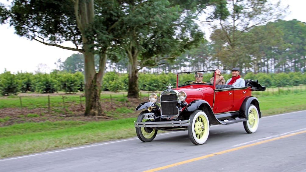 Show item 4 of 5. driving an antique car on the road in Argentina