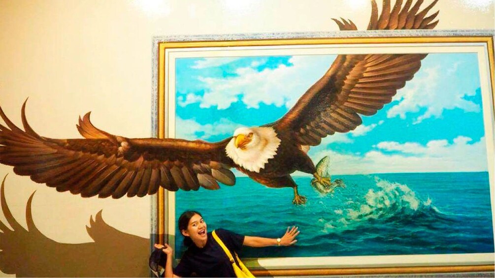 แสดงภาพที่ 2 จาก 4 Girl posing with optical illusion painting of an eagle in Pattaya