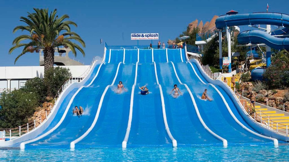 Ver elemento 4 de 4. People on a row of waterslides at Slide and Splash Waterpark in Algarve