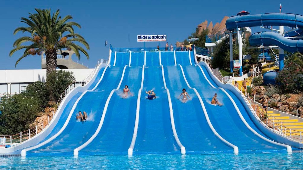 People on a row of waterslides at Slide and Splash Waterpark in Algarve