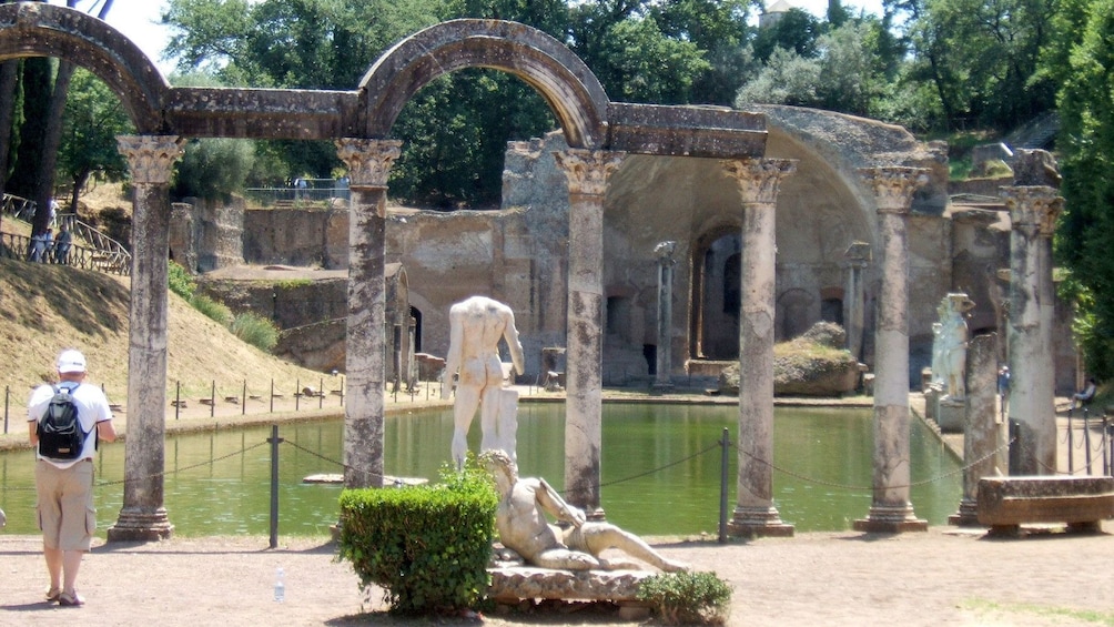 Person walking amongst ancient statues and architecture in Tivoli