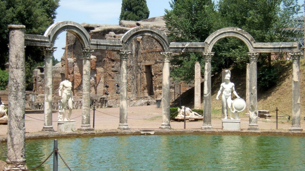 Pool surrounded by sculptures and ruins in Tivoli