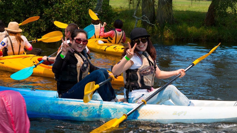 Show item 3 of 4. Pair of women kayaking with group in Sydney
