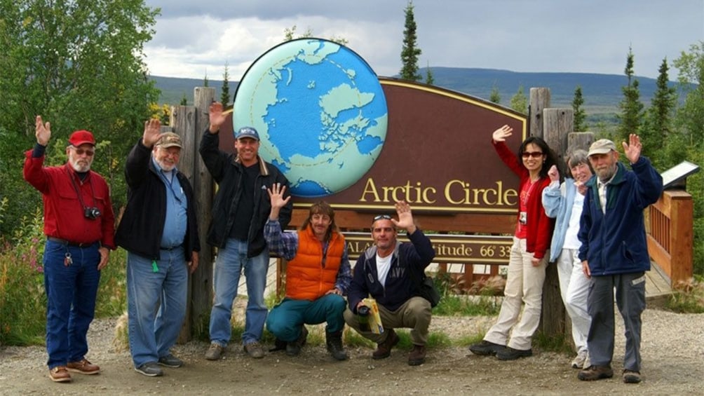 Tour group at the sign for the Arctic Circle in Alaska