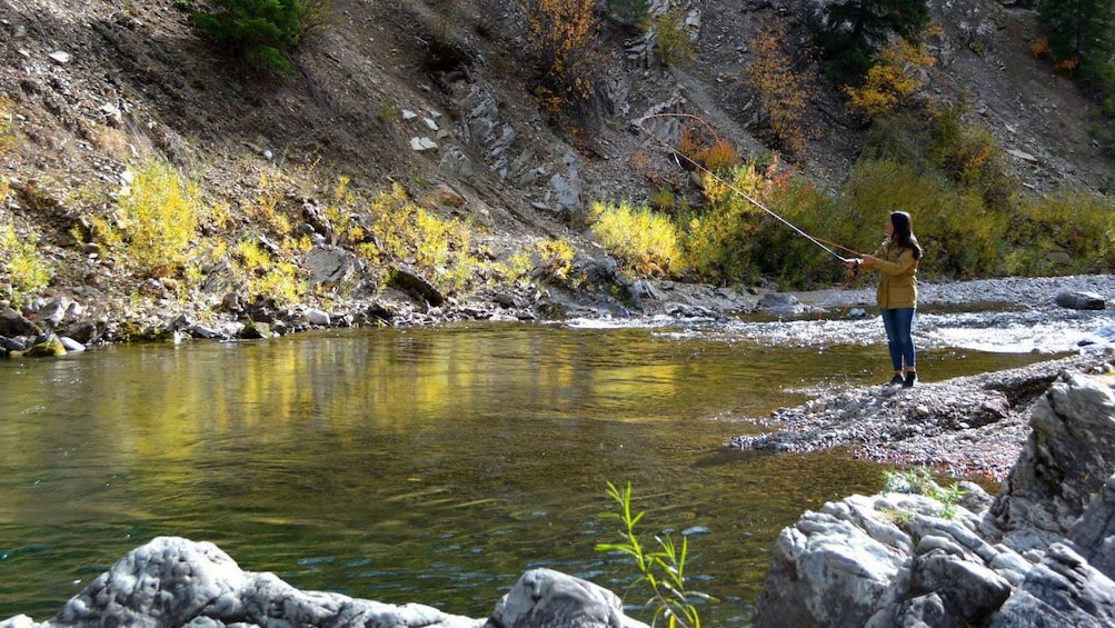 Fly fishing woman on a riverbank in Fairbanks