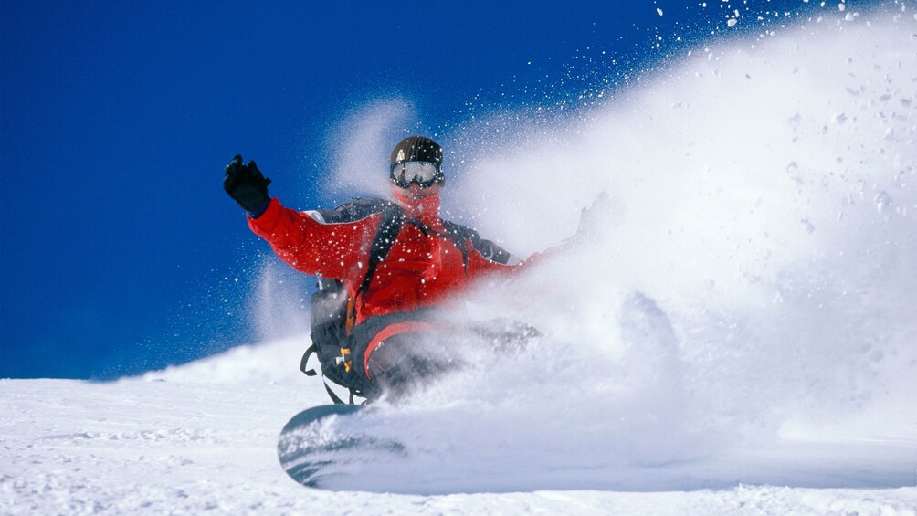 Show item 3 of 5. Snowboarder on a mountain under a blue sky in Colorado