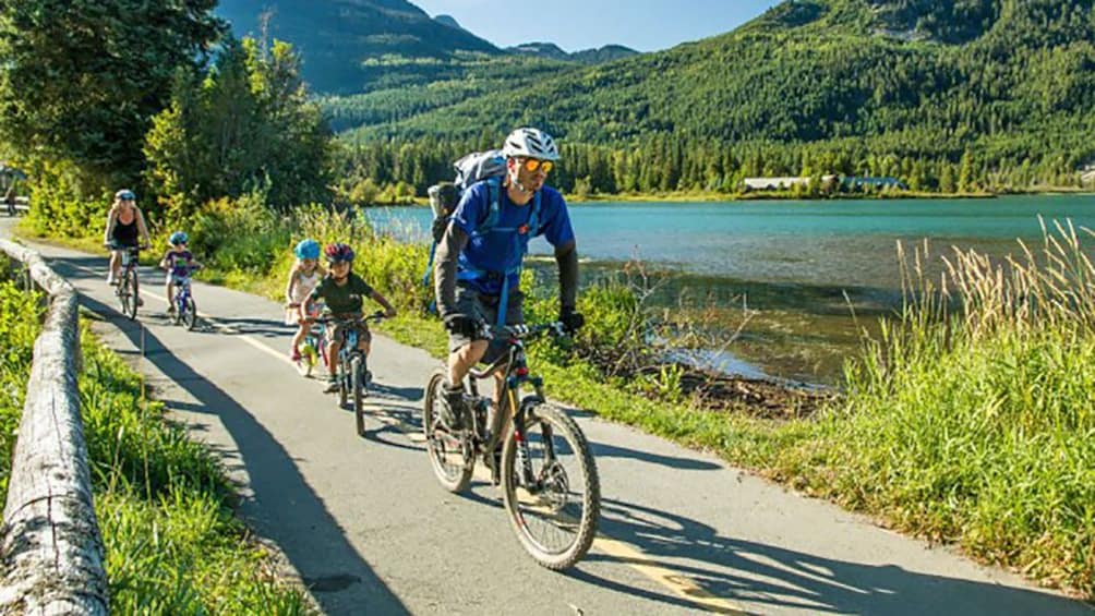 family biking on a narrow path in Canada