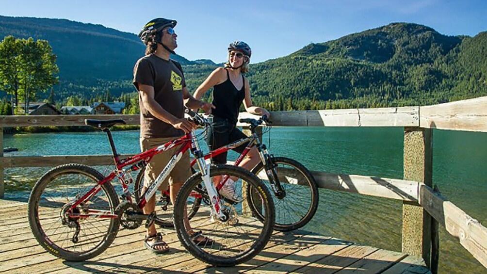 couple resting with their bikes along the lake in Canada