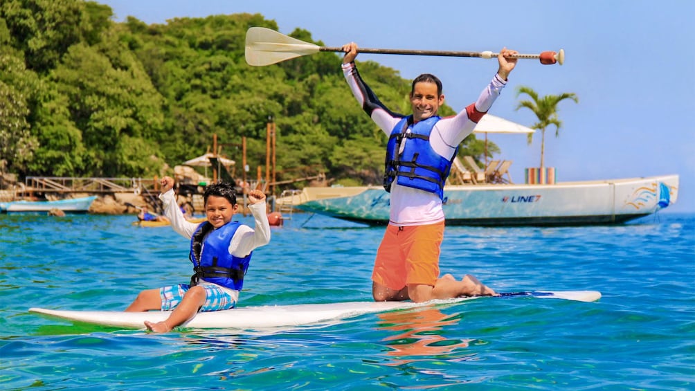 Father and son on a standup paddleboarding adventure in Nayarit, Mexico