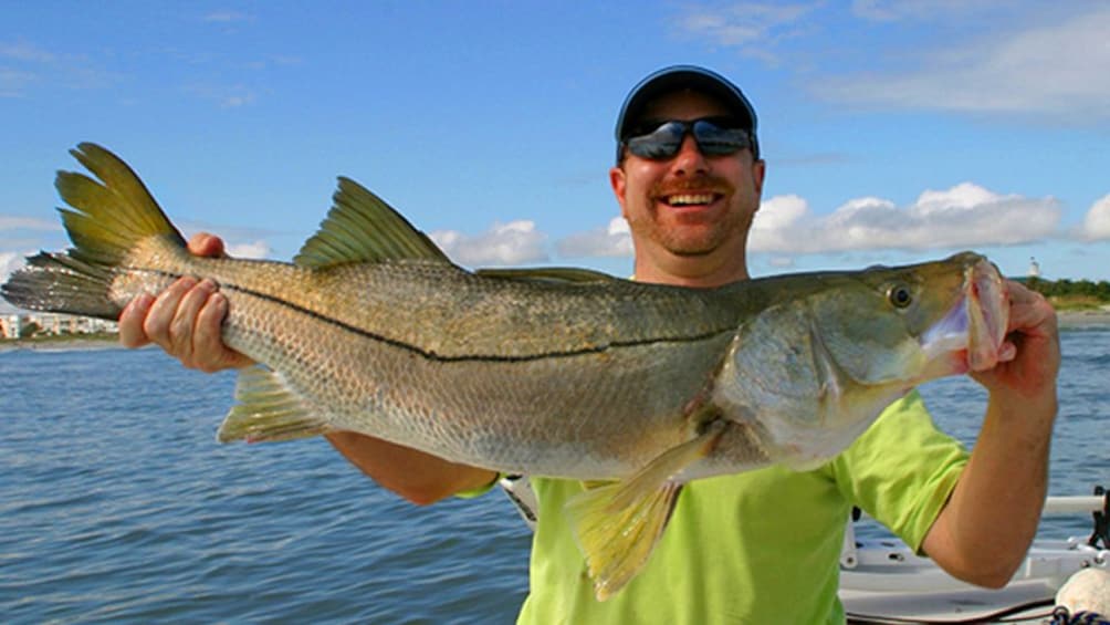 Show item 1 of 9. Man holding a fish