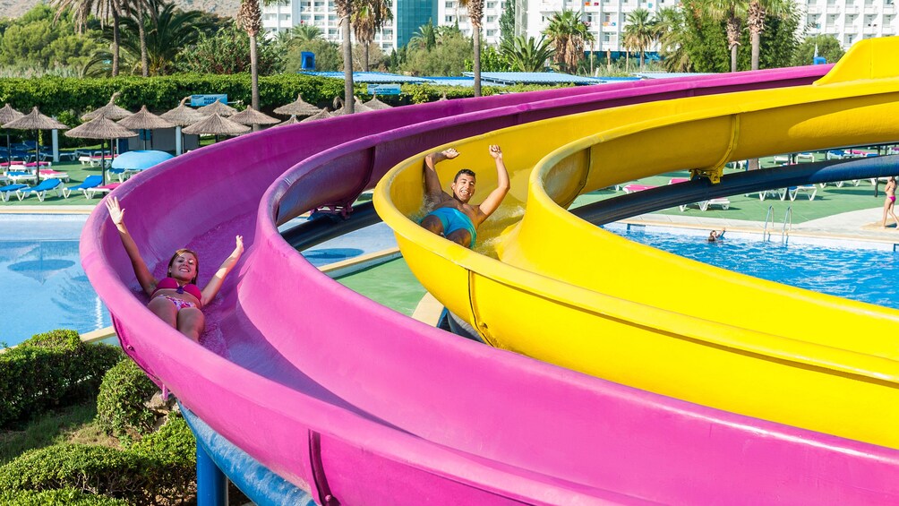 Two people going down water slides at hidropark alcudia