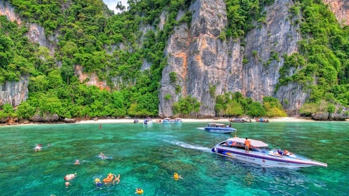swimmers near a speedboat at the beach in Thailand