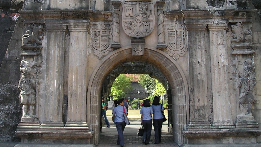 Women walk through Stone building