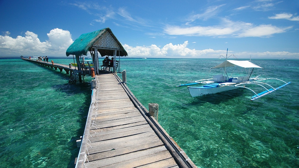 Boardwalk over the water with boat on the ready in Cebu Island.