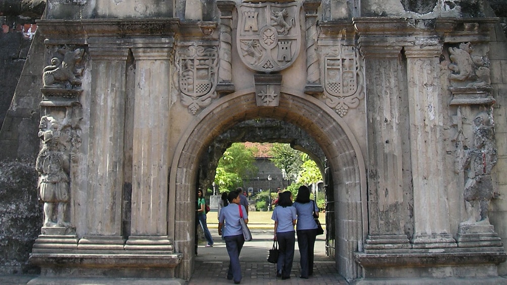 People walking through stone tunnel