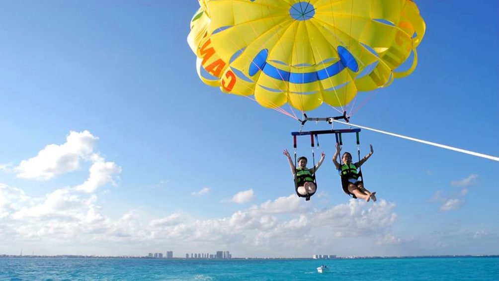 friends having fun parasailing in Cancun
